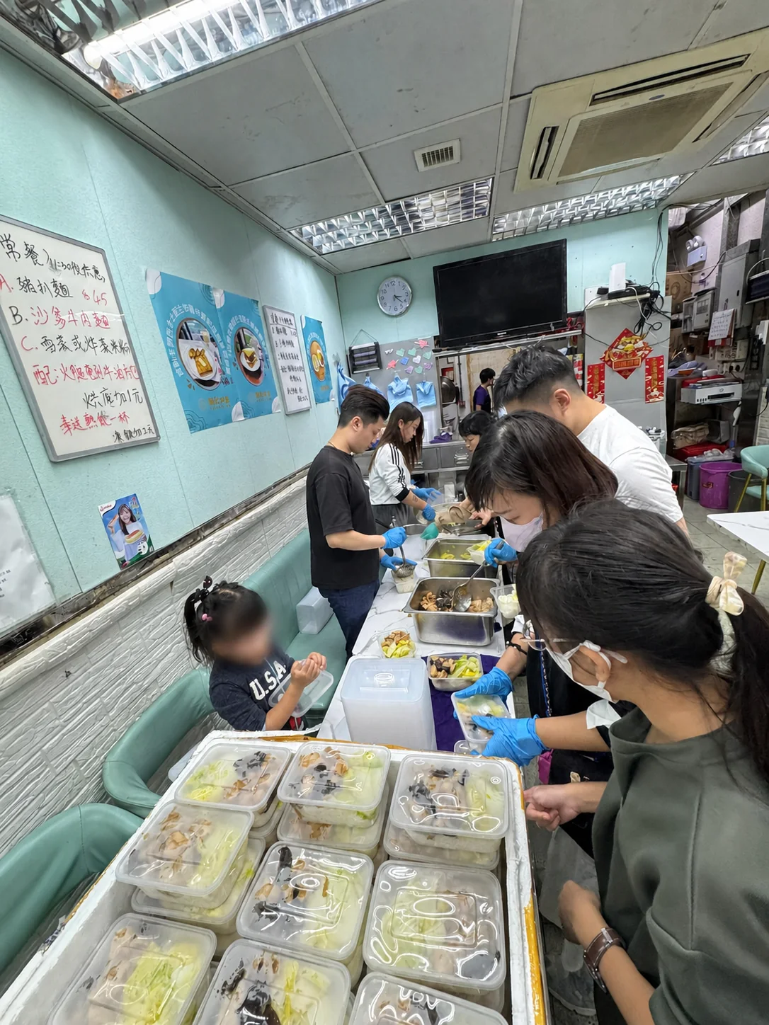 義工在餐廳內分工準備及包裝飯餐